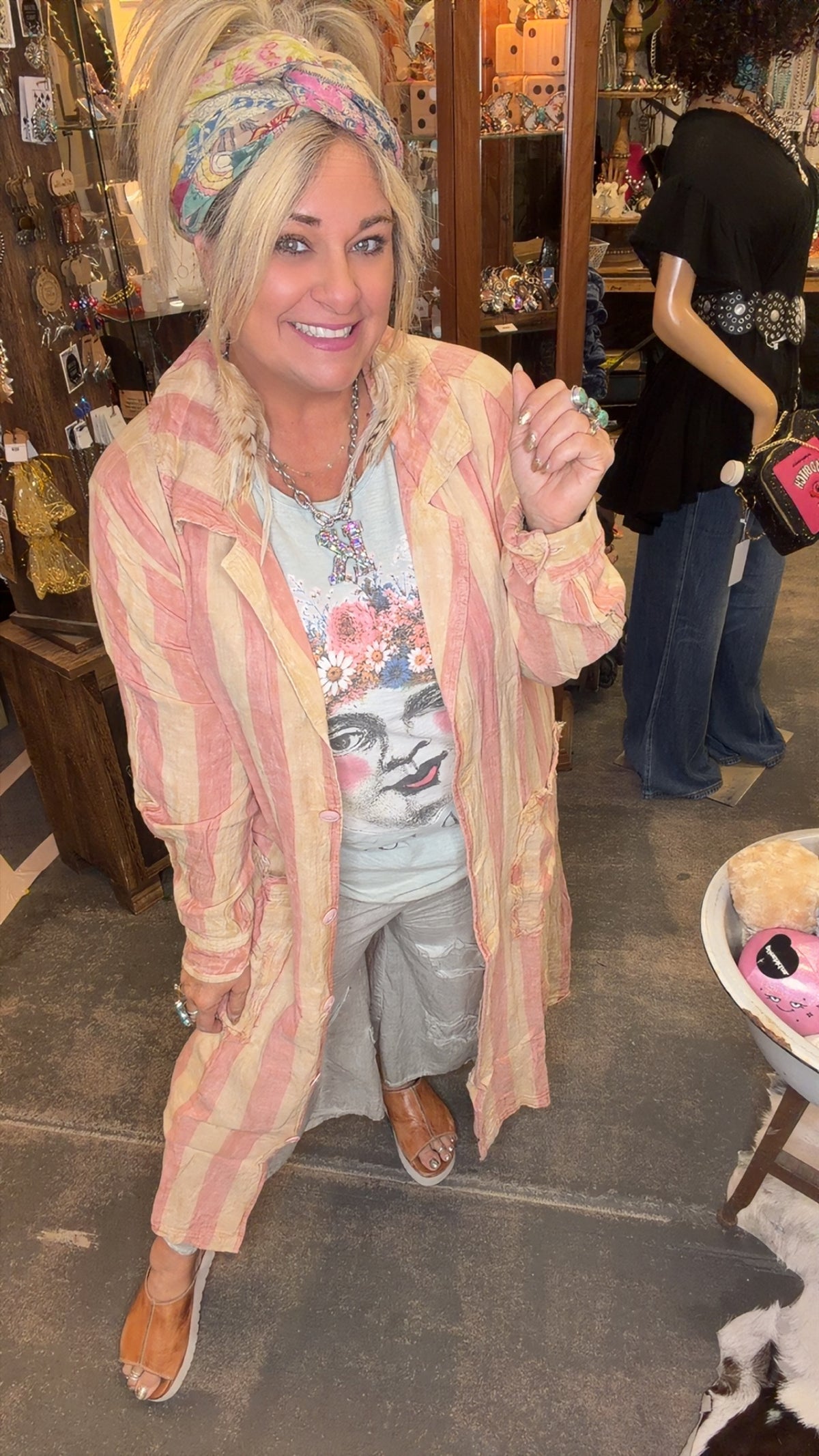 A person wearing a bubblegum pink duster with stripes, featuring an oversized fit and notched collar.