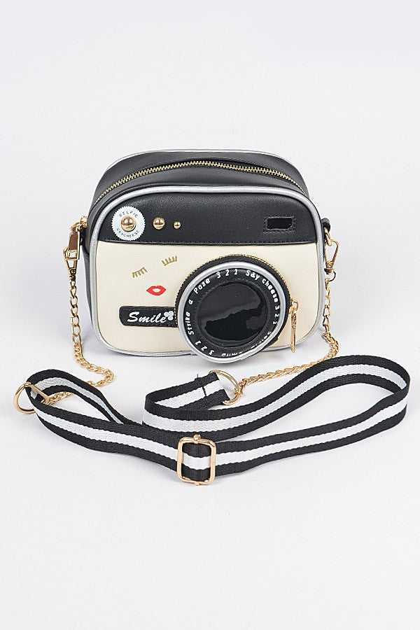 Camera-shaped handbag with a strap on a white background